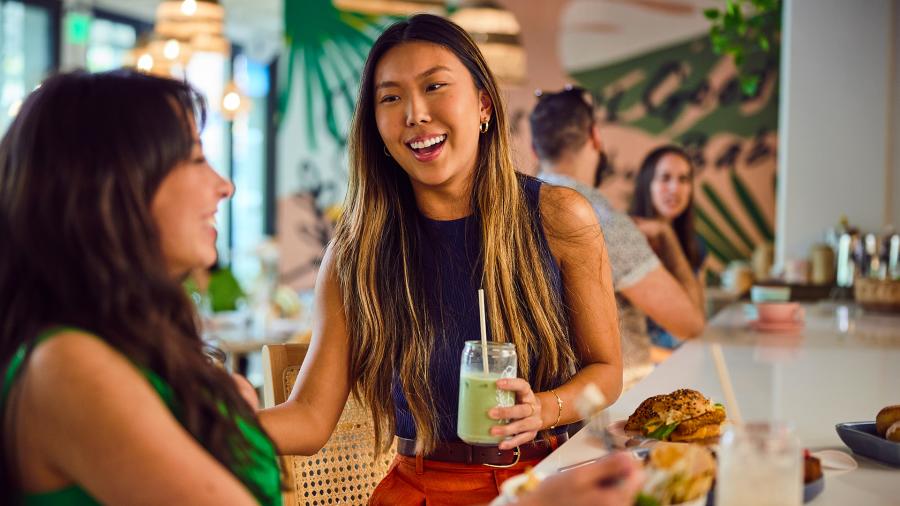 Two girls laughing over lunch