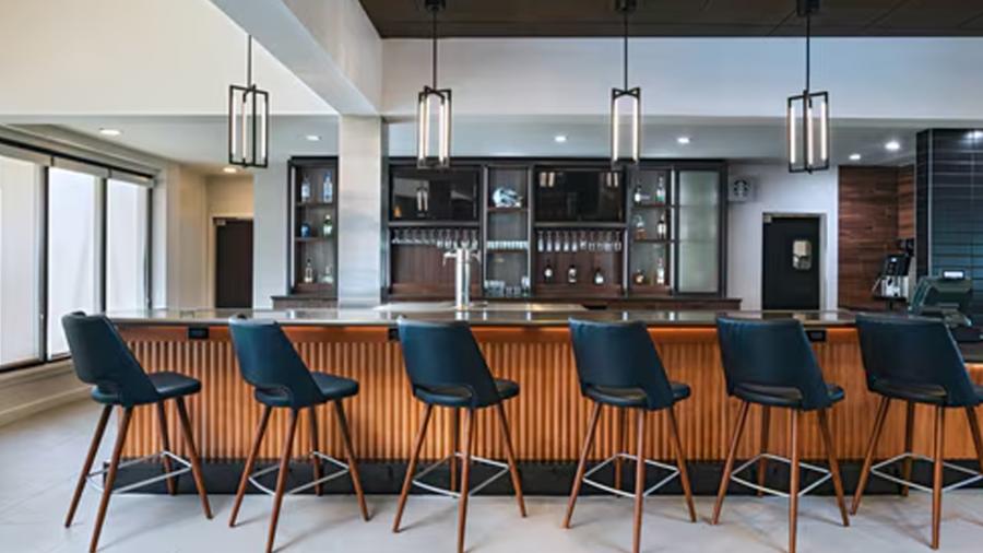 Bar area of hotel with chairs facing bar.