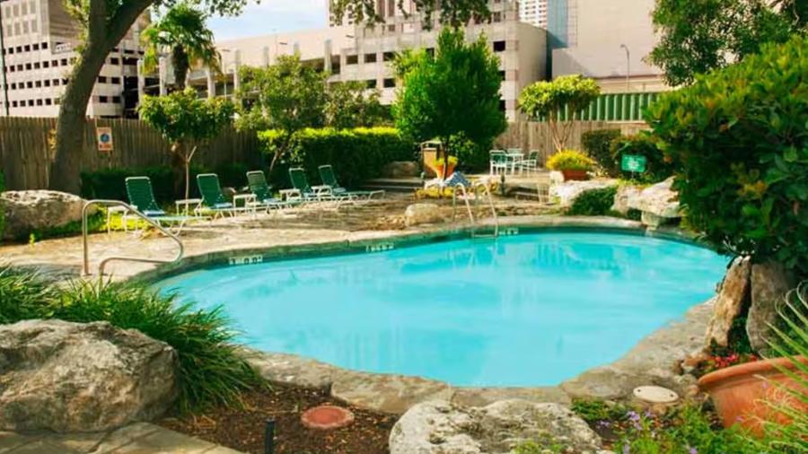 Exterior hotel pool with rock structures surrounding it.