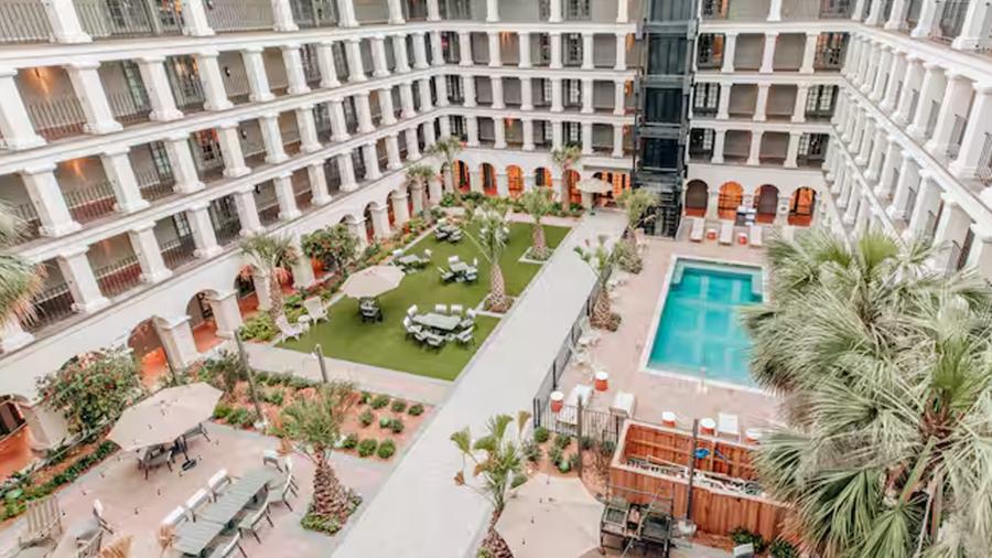 Hotel courtyard with pool and palm trees.