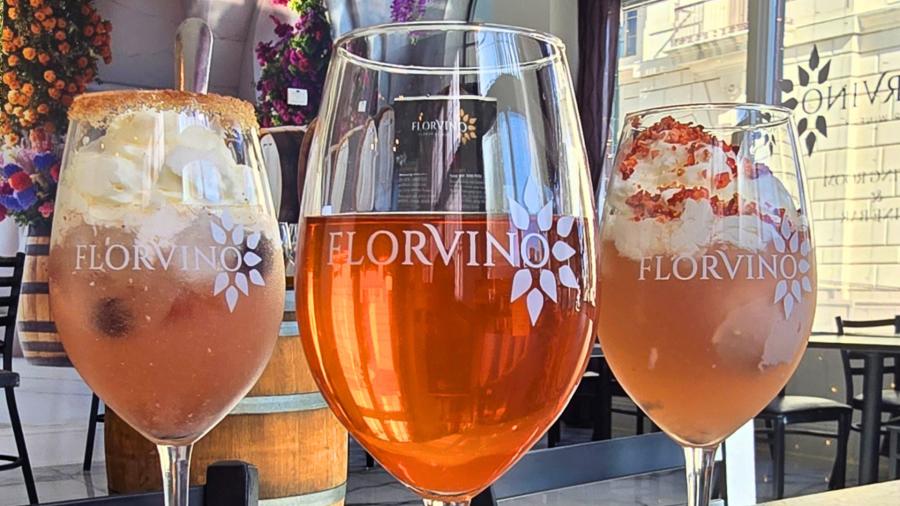 Three glasses filled with wine and "FlorVino" logo facing toward camera.