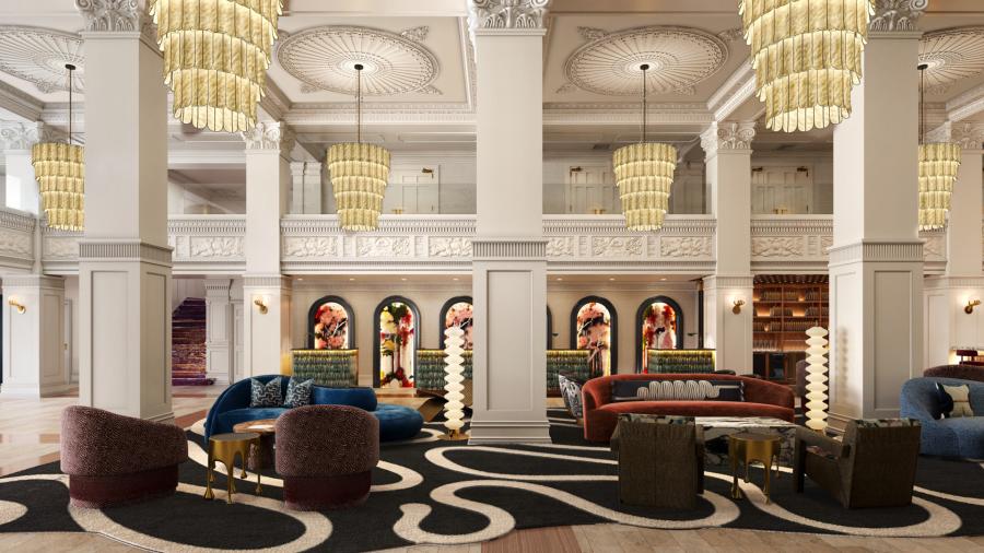 Beautiful hotel lobby with large chandeliers, elegant carpet and oversized lounge chairs.