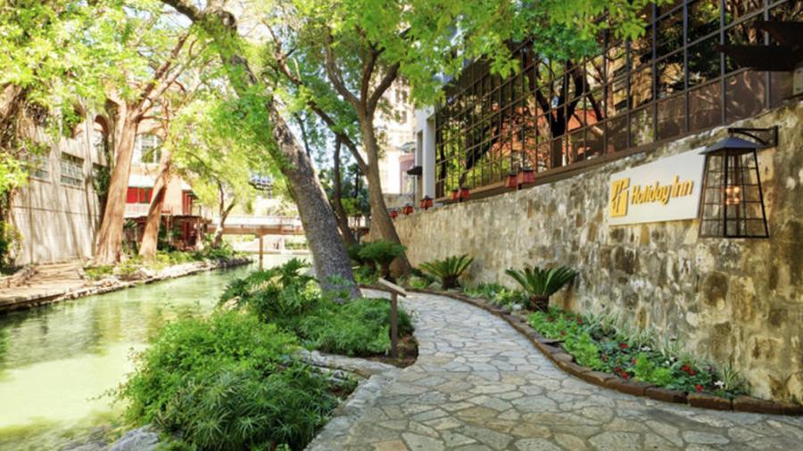 Cobblestone path and trees in front of hotel.