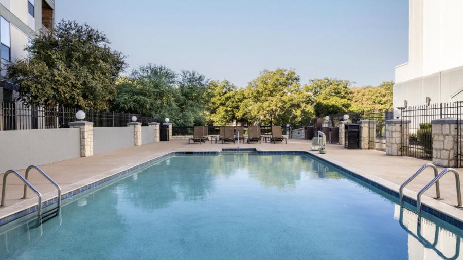 Outdoor hotel pool with clear sky in background.