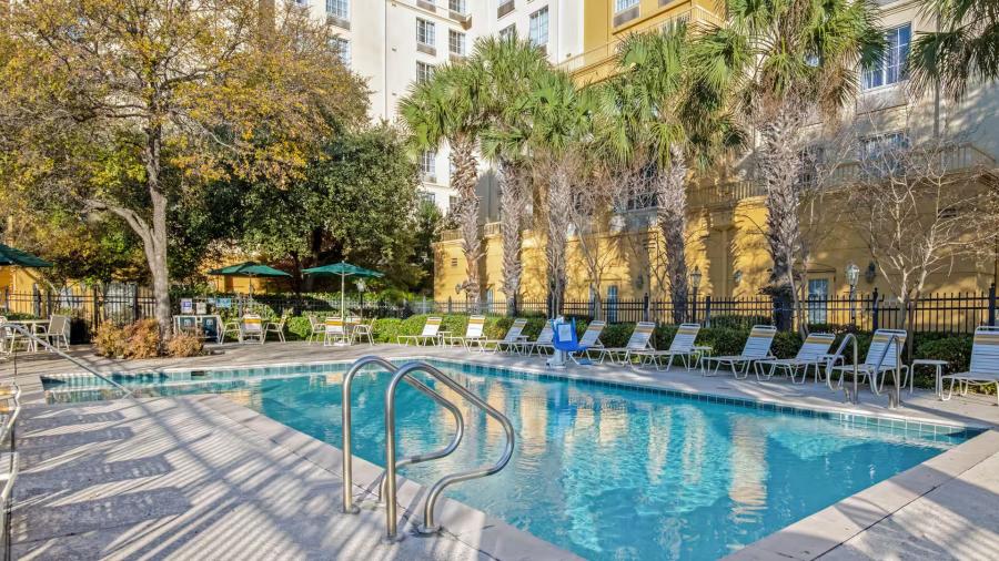 Hotel pool with lounge chairs surrounding it.