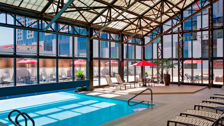 Indoor/outdoor pool at hotel with red umbrellas.