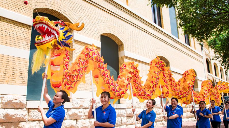 Dragon dancers holding up dragon.