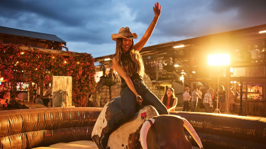Girl on mechanical bull at Tejas Rodeo