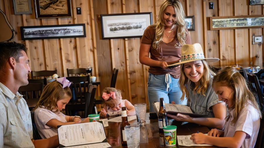 Family sitting at table ordering food at Tejas Rodeo.