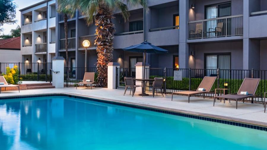 Hotel pool surrounded by lounge chairs.