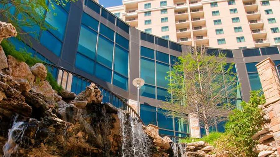 Exterior of hotel building with waterfall over rock display.