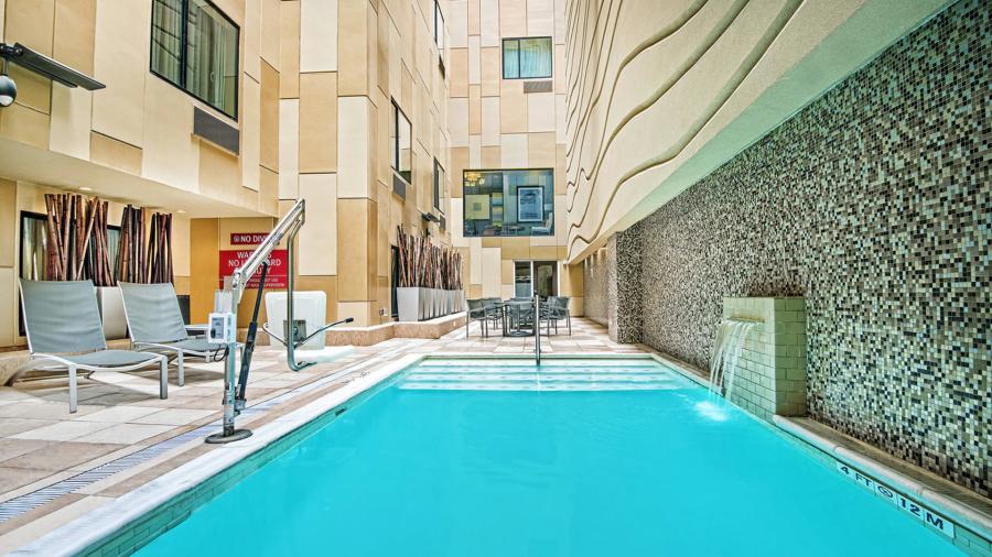 Hotel pool with lounge seating nearby.