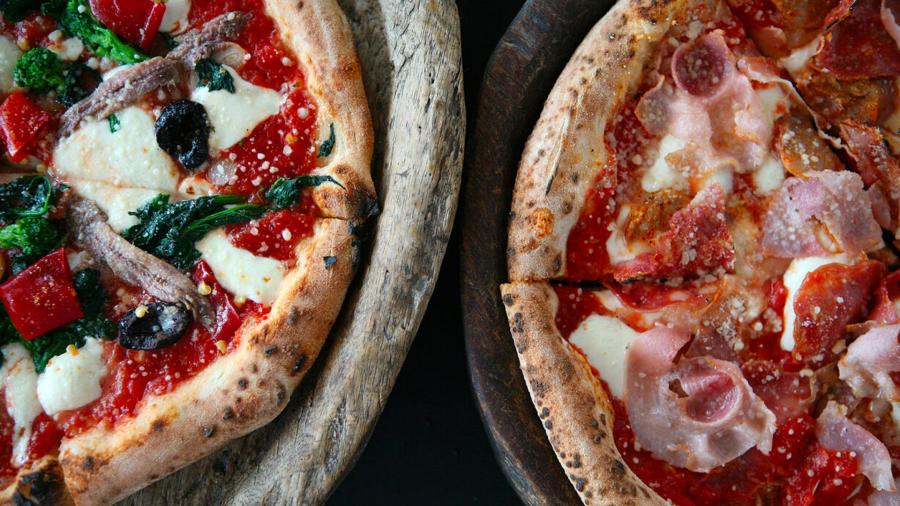 Overhead view of two pizzas side by side.