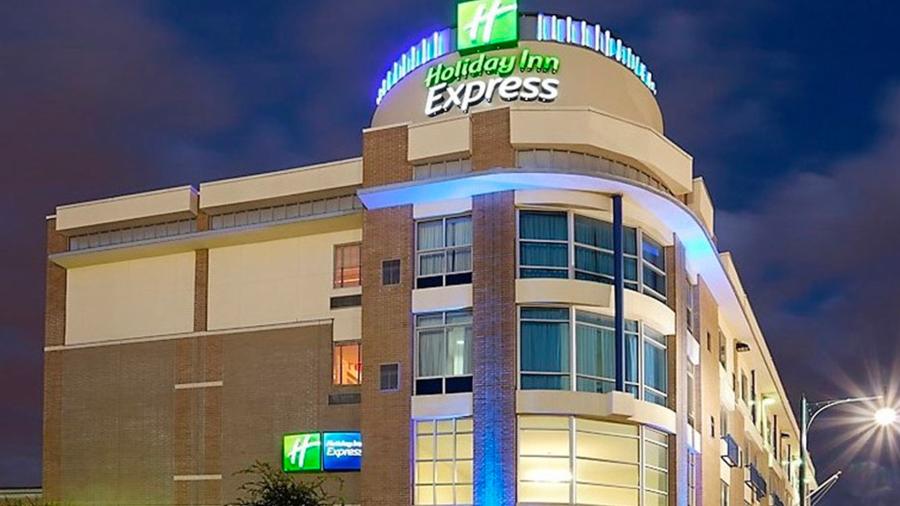 Exterior hotel building at night with logo lit up