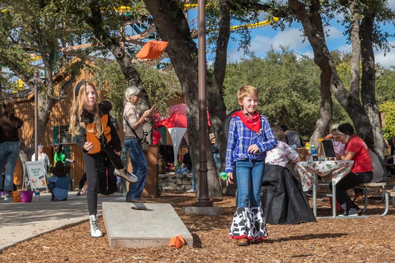 kids playing cornhole outside