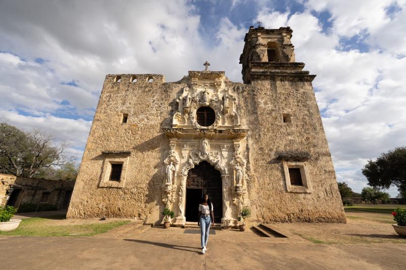 Woman standing in front of San Antonio Mission