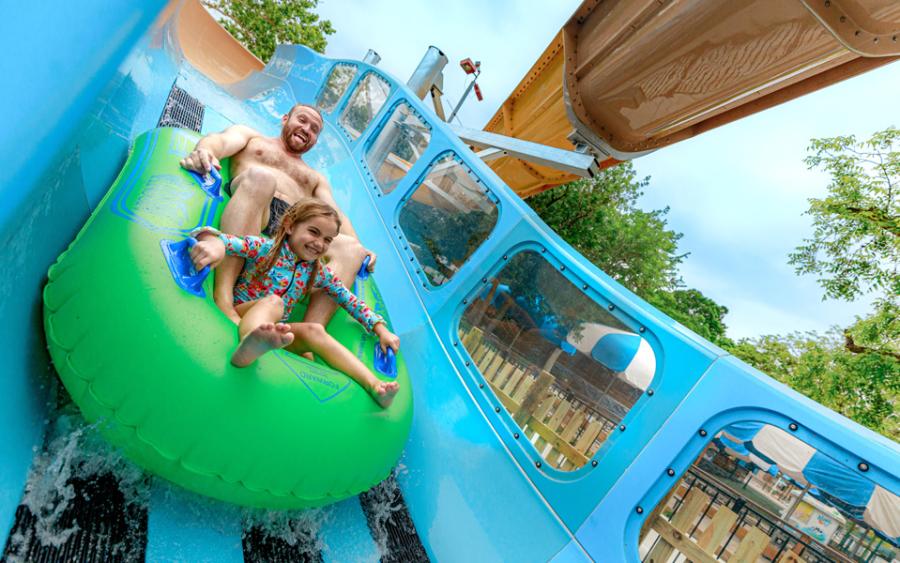 Father and daughter on waterslide together.