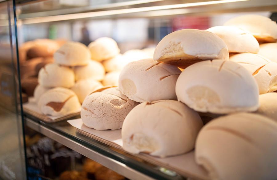 Conchas stacked on top of each other in display case at La Panaderia.