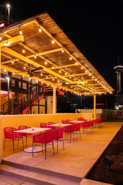 outdoor patio with pink chairs with string lights nighttime