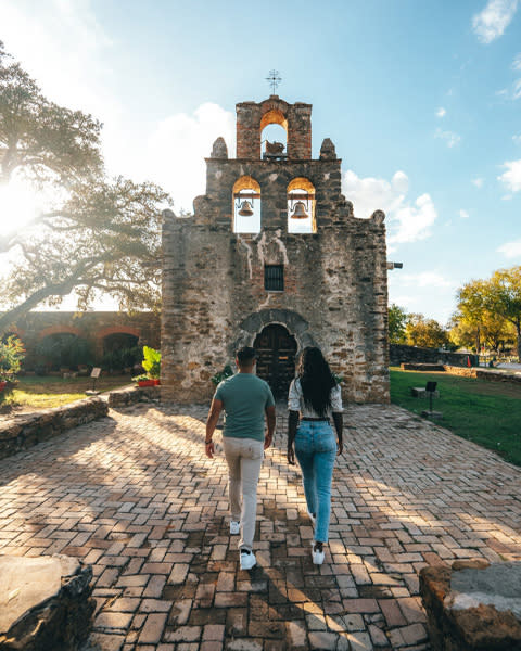 Two people walking toward mission