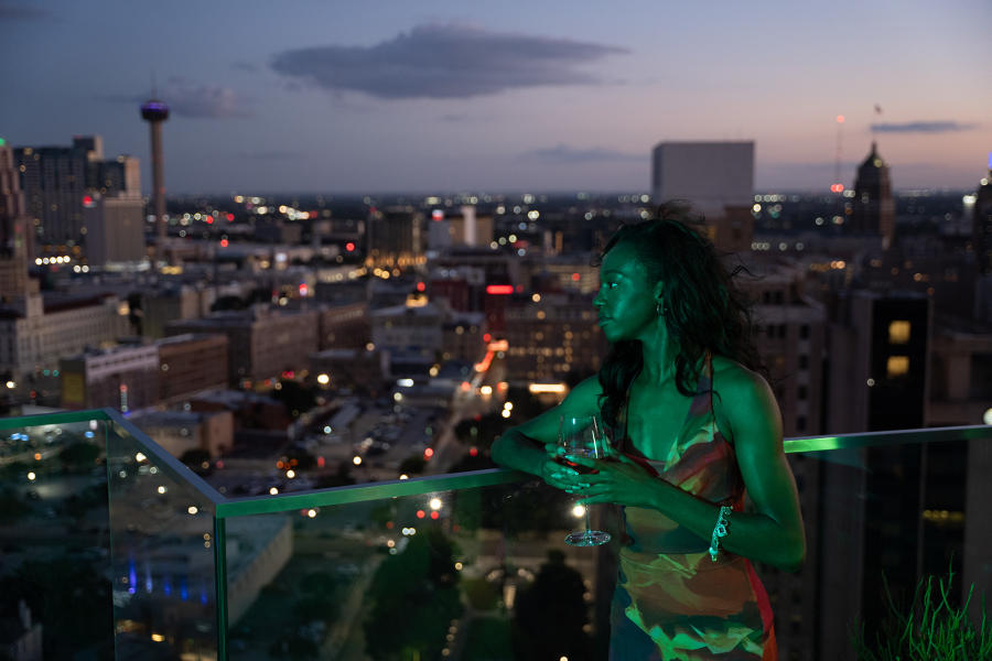 Woman at rooftop bar with a drink at The Moon's Daughters