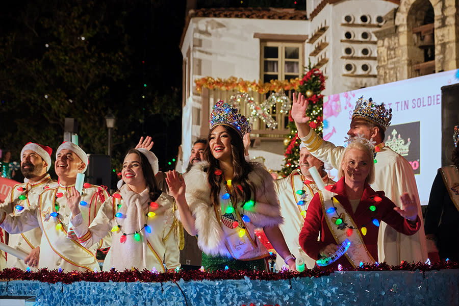 People dressed as fake royalty with holiday light necklaces