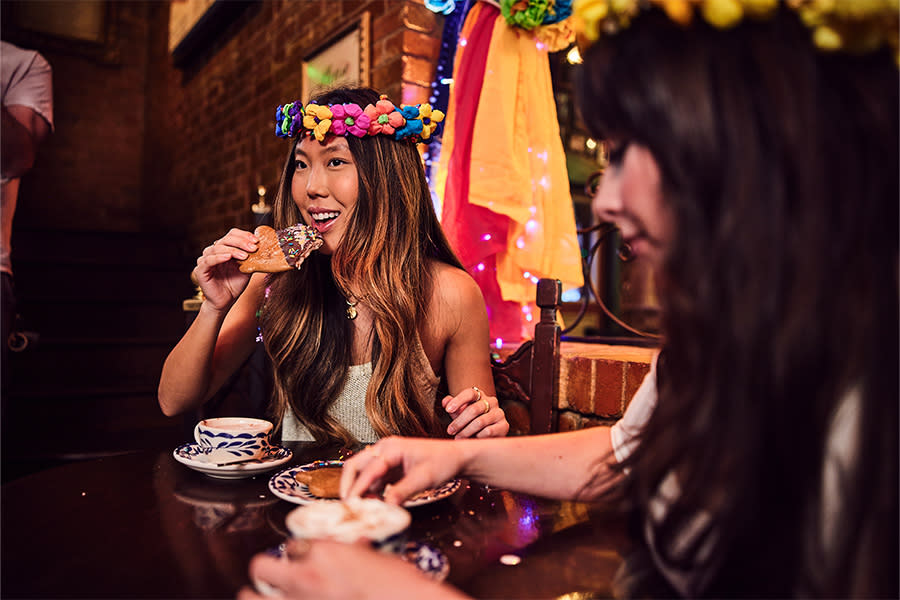Girl eating pastry dunked in hot chocolate