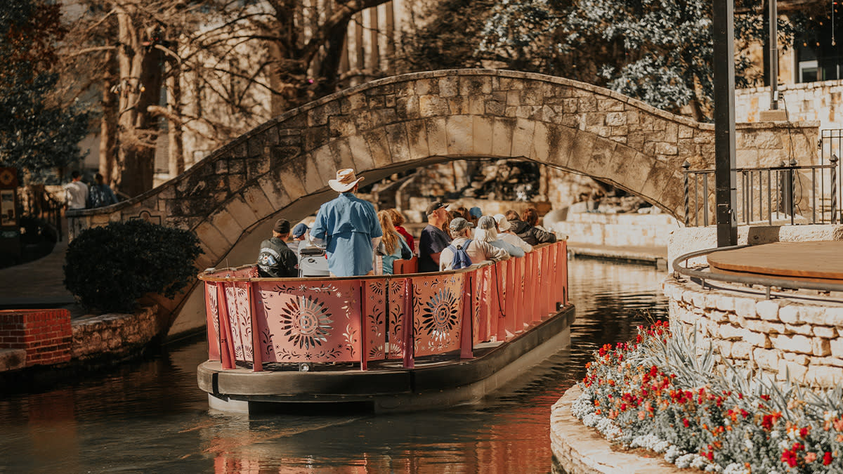 Barge carrying people floating down River Walk