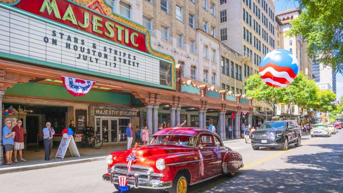 Classic red car driving in front of Majestic Theatre