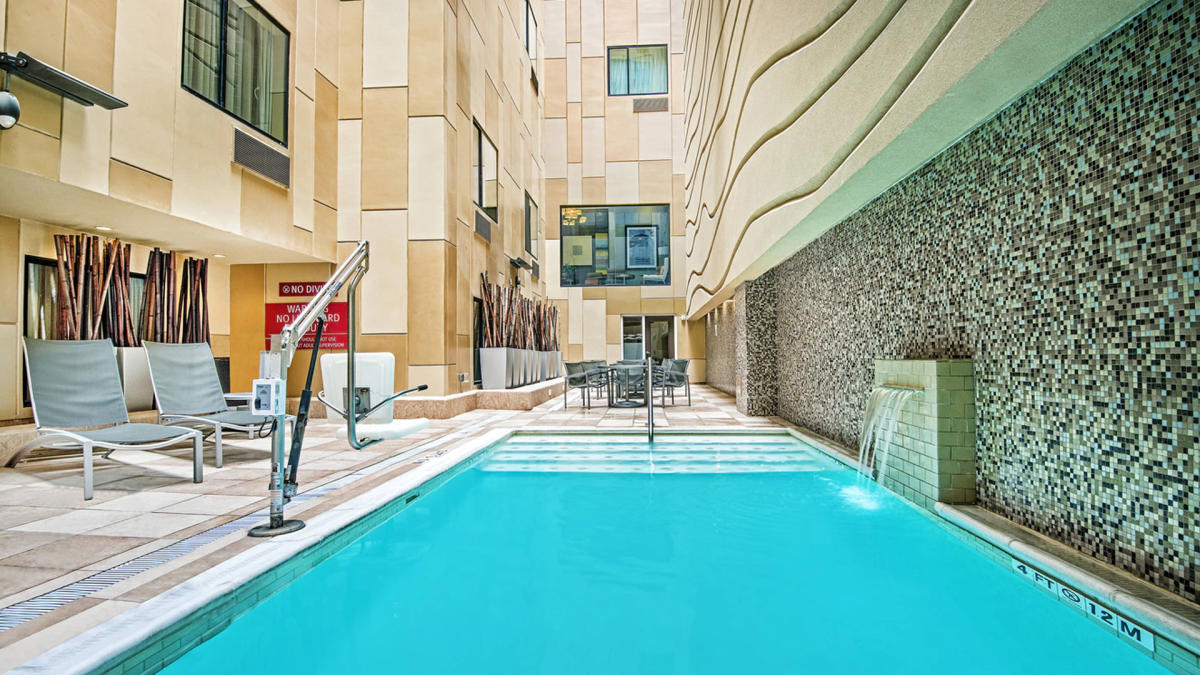 Hotel pool with lounge seating nearby.