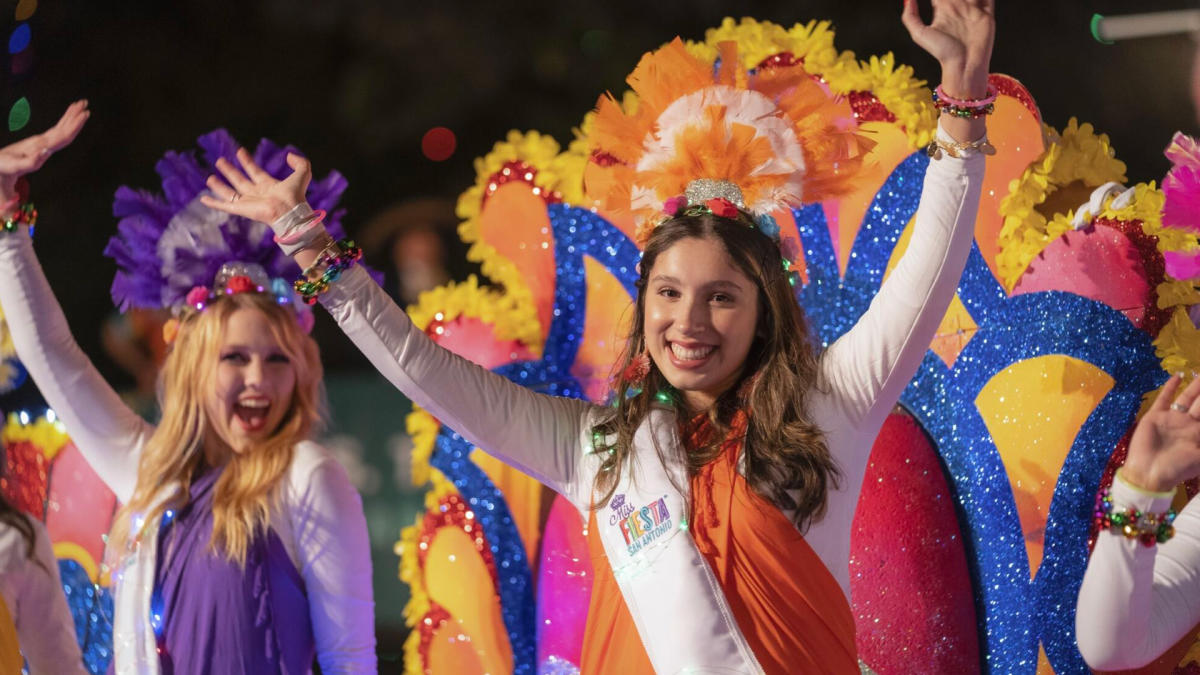 2 girls waving from parade float
