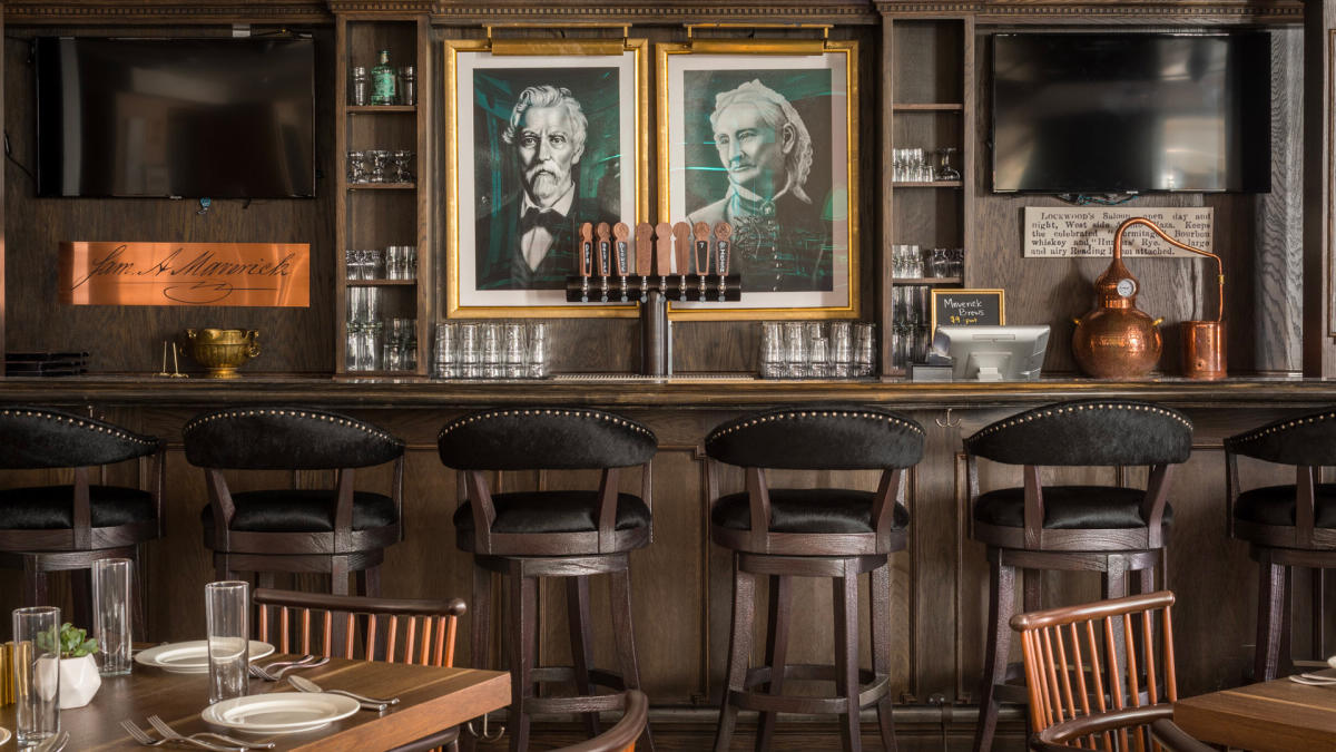 Bar top with portaits hung behind counter