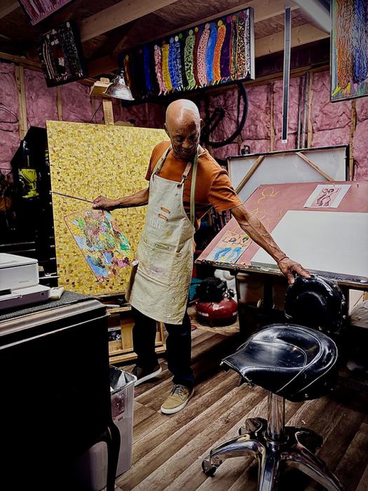 Artist D'Lani Middleton painting on a canvas