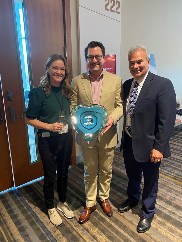 3 professionals standing with an award