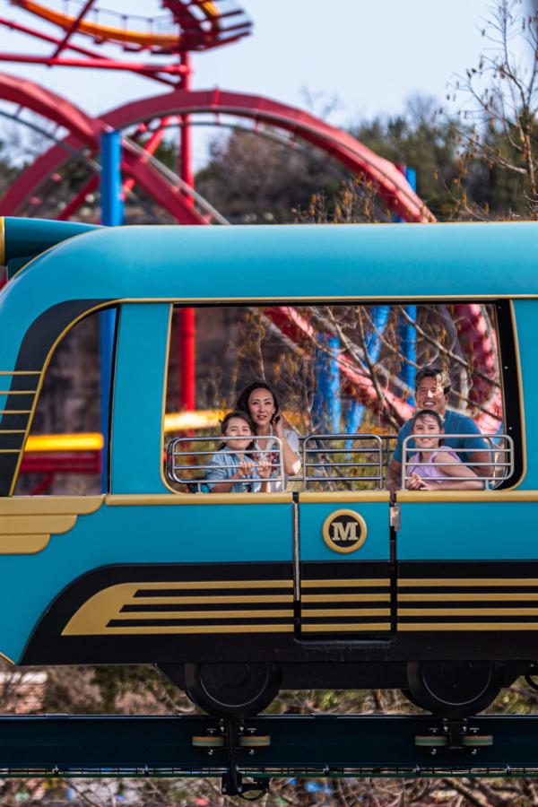 Family inside blue train ride at Six Flags Fiesta Texas.