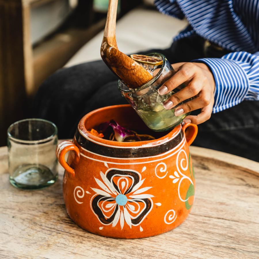 Hand scooping margarita out of cantarito