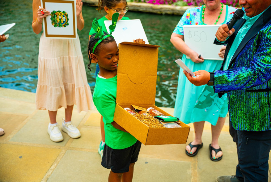 child holding prize box at river walk