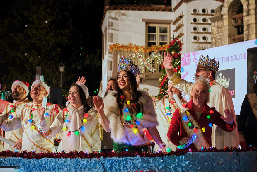 People dressed as fake royalty with holiday light necklaces