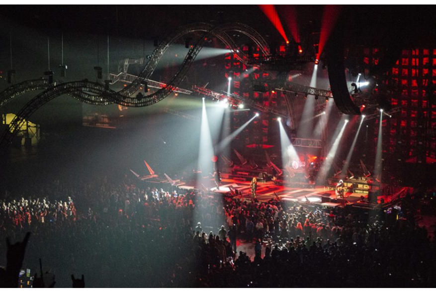 Inside arena with spotlights over crowd in the Alamodome.