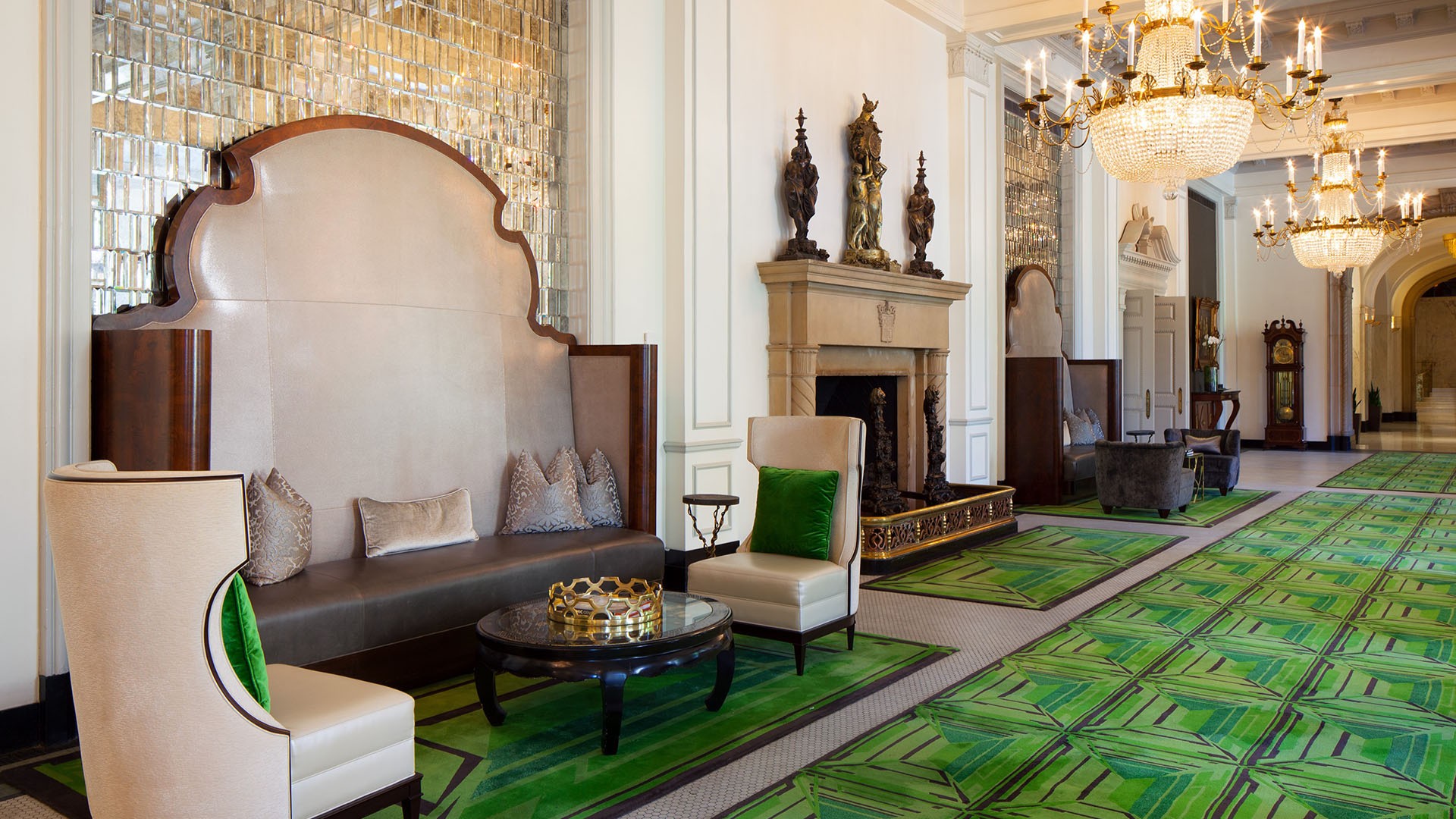 Hotel lobby with green carpeting and luxury chandeliers at St. Anthony Hotel in San Antonio.