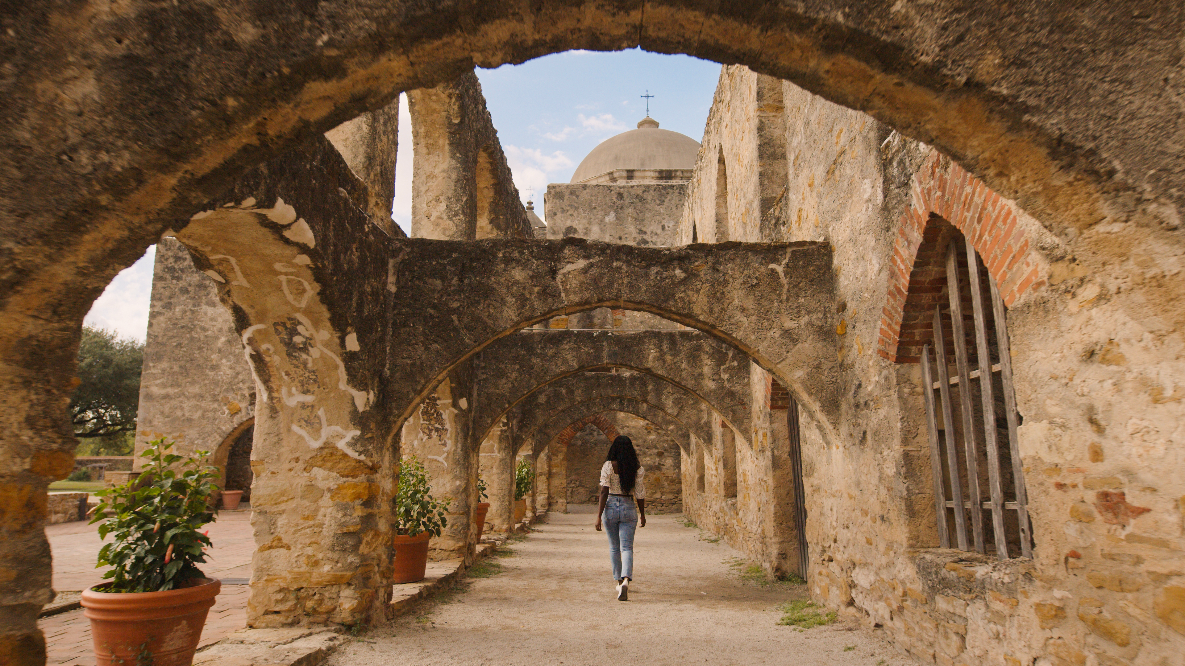 Woman walking through Mission San Jose in San Antonio.