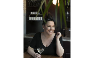 Headshot of Kate Williams holding a cocktail
