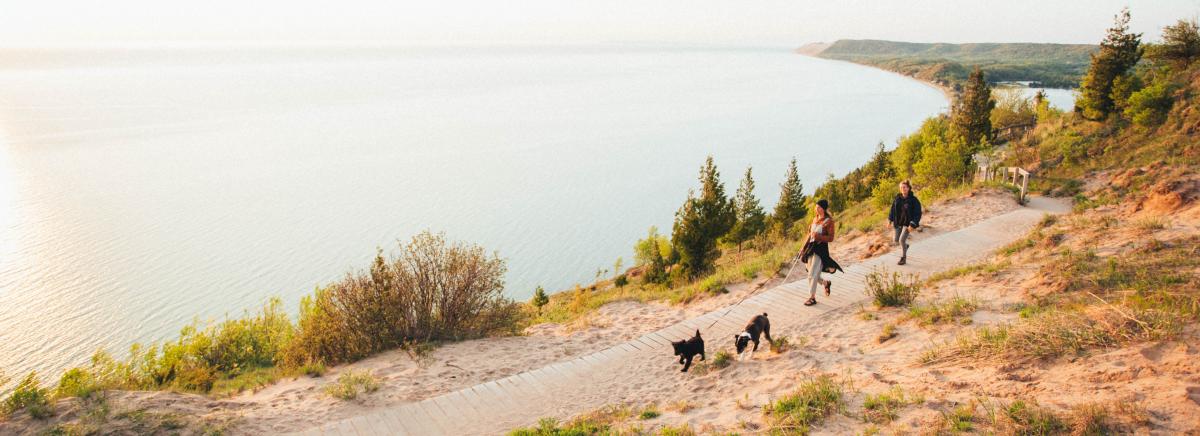 Couple hiking with dogs at Sleeping Bear Dunes