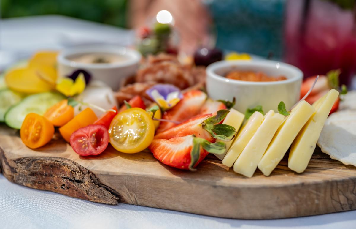 Artfully arranged cheeseboard at Artisan restaurant, featuring a selection of cheeses, cured meats, fresh fruit, and accompaniments.