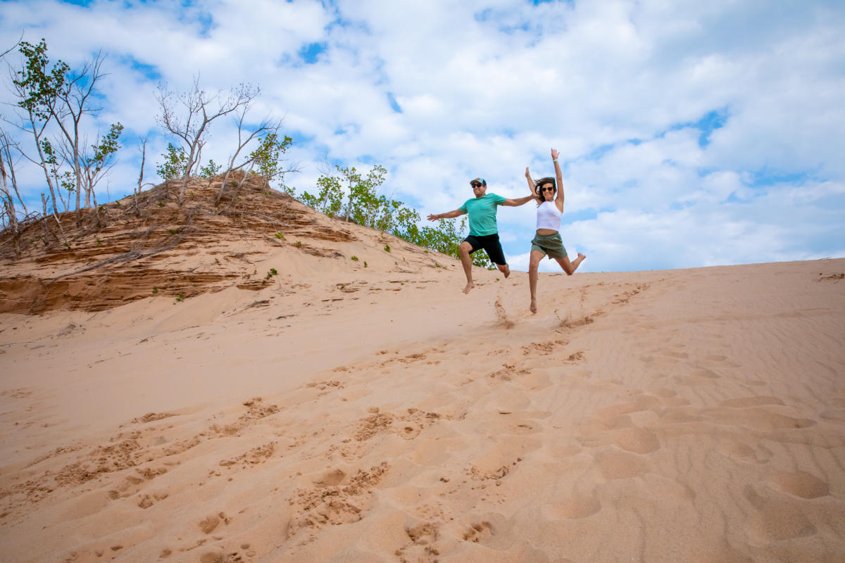 couple running down the Sleeping Bear Sand Dunes