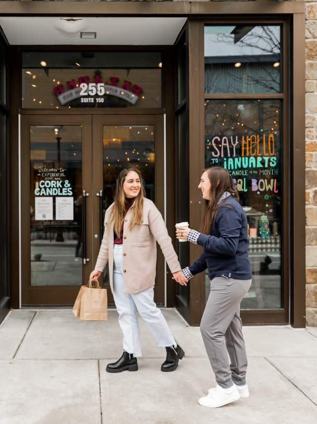 Female couple holding hands outside Cork and Candle in King of Prussia