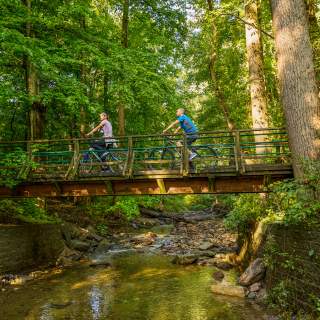 People biking over bridge on Wissahickon Trail