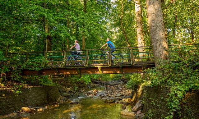 People biking over bridge on Wissahickon Trail