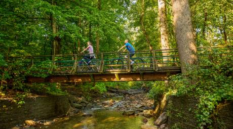 People biking over bridge on Wissahickon Trail