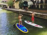 Couple paddleboarding on river